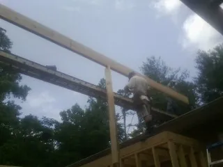 Carpenter setting a ridge beam over a new addition frame — Ice Dam Removal by Roofing Brothers in Peckville
