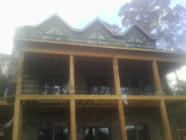 Dormers and porch framing on a large log home under construction — Roof Coating work by our crew in Peckville