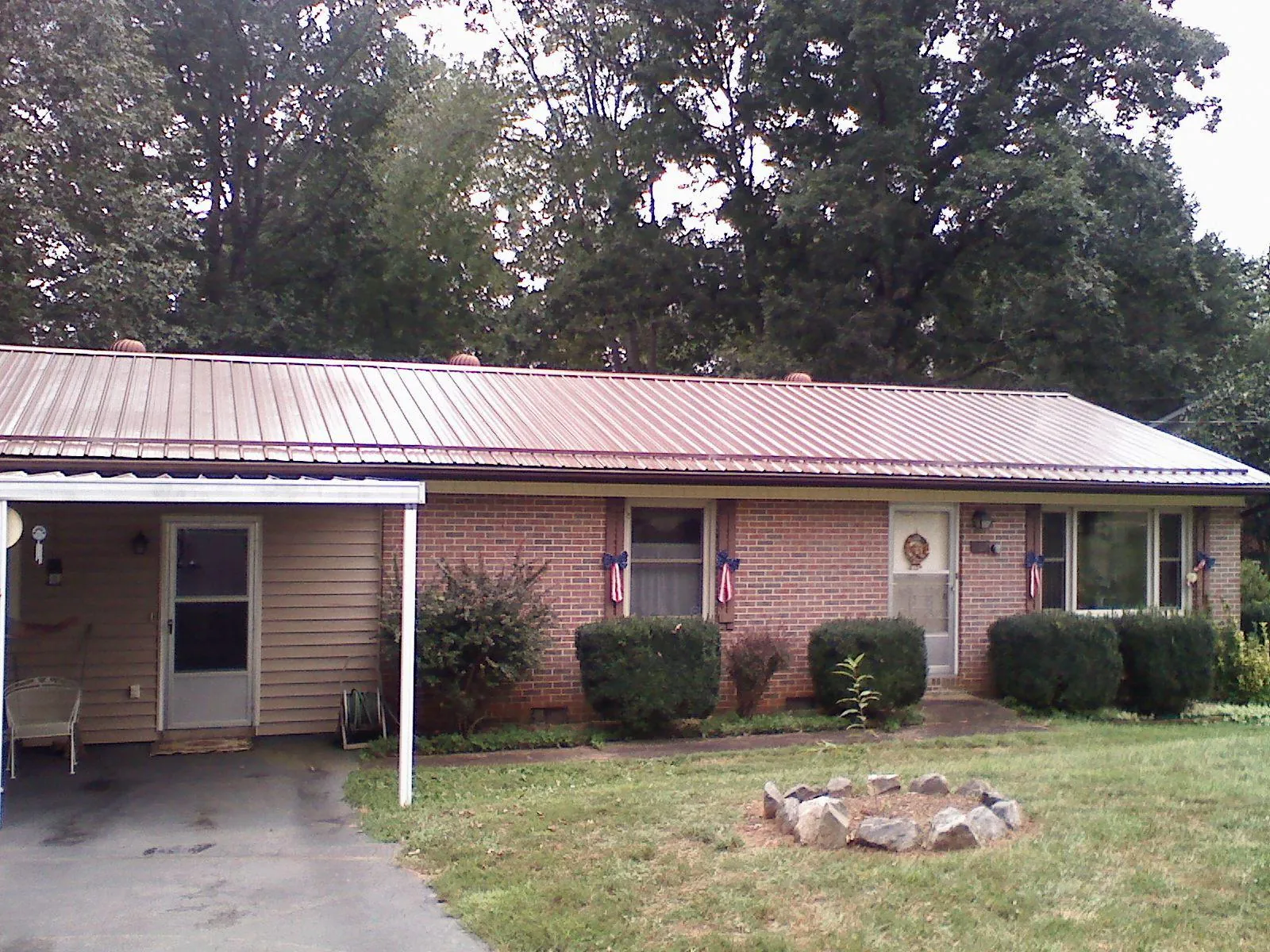 Bronze metal roof and carport on a brick ranch home — Roof Repair work by our crew in Peckville